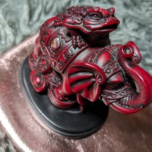 Wealth token frog on top of elephant